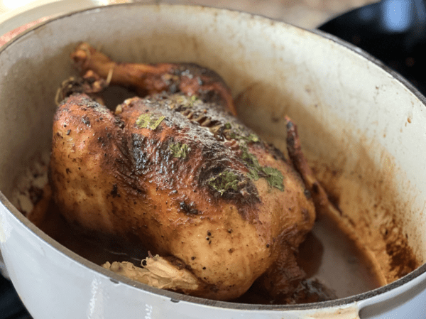 Roasted chicken with herbs in a pot.